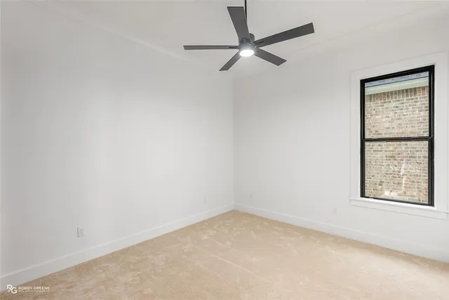 an empty room with a window and a fan