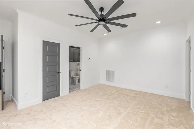 an empty room with closet and fan