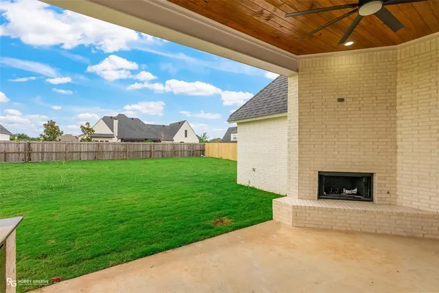 a view of a field with sitting area and fence