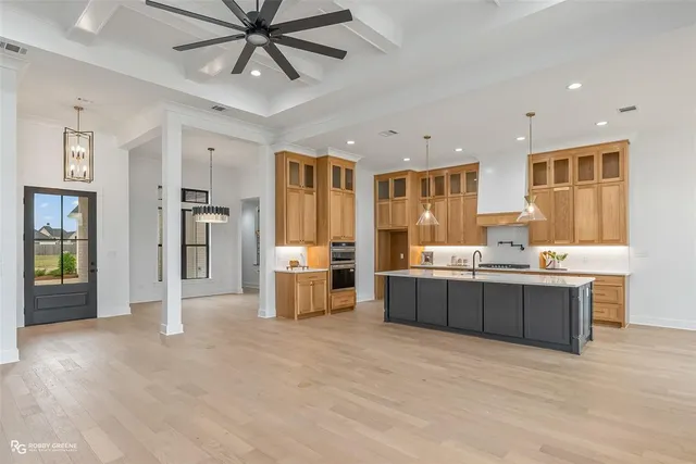 a kitchen with stainless steel appliances kitchen island granite countertop a refrigerator and a sink