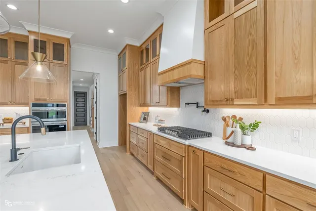 a kitchen with stainless steel appliances a sink a stove and a refrigerator with wooden floor