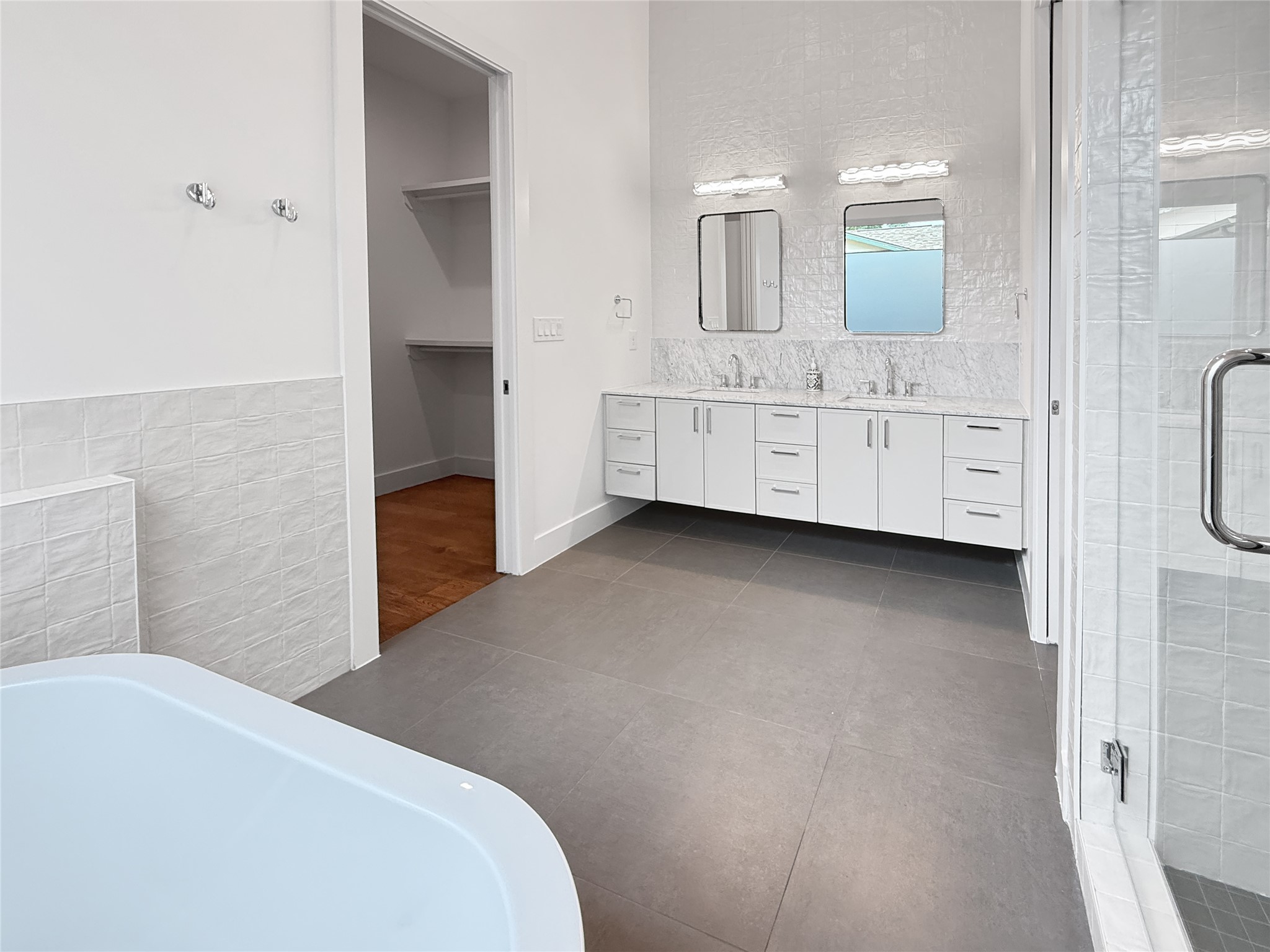 127 Frederick Street Austin, TX 78704 - Photo 15 of 34 Spacious bathroom featuring a floating double vanity with a stone countertop, individual mirrors, and contemporary lighting