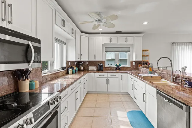 a large kitchen with stainless steel appliances granite countertop a stove and a sink