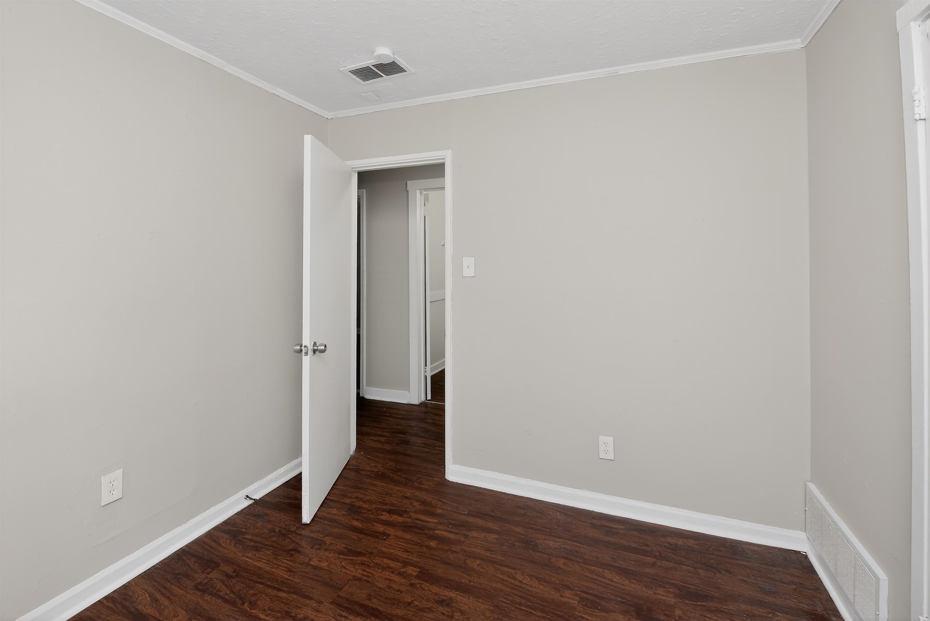 4838 Manson Road Memphis, TN 38109 - Photo 8 of 28 Interior room featuring neutral wall paint, wood-finish flooring, white baseboards, and crown molding