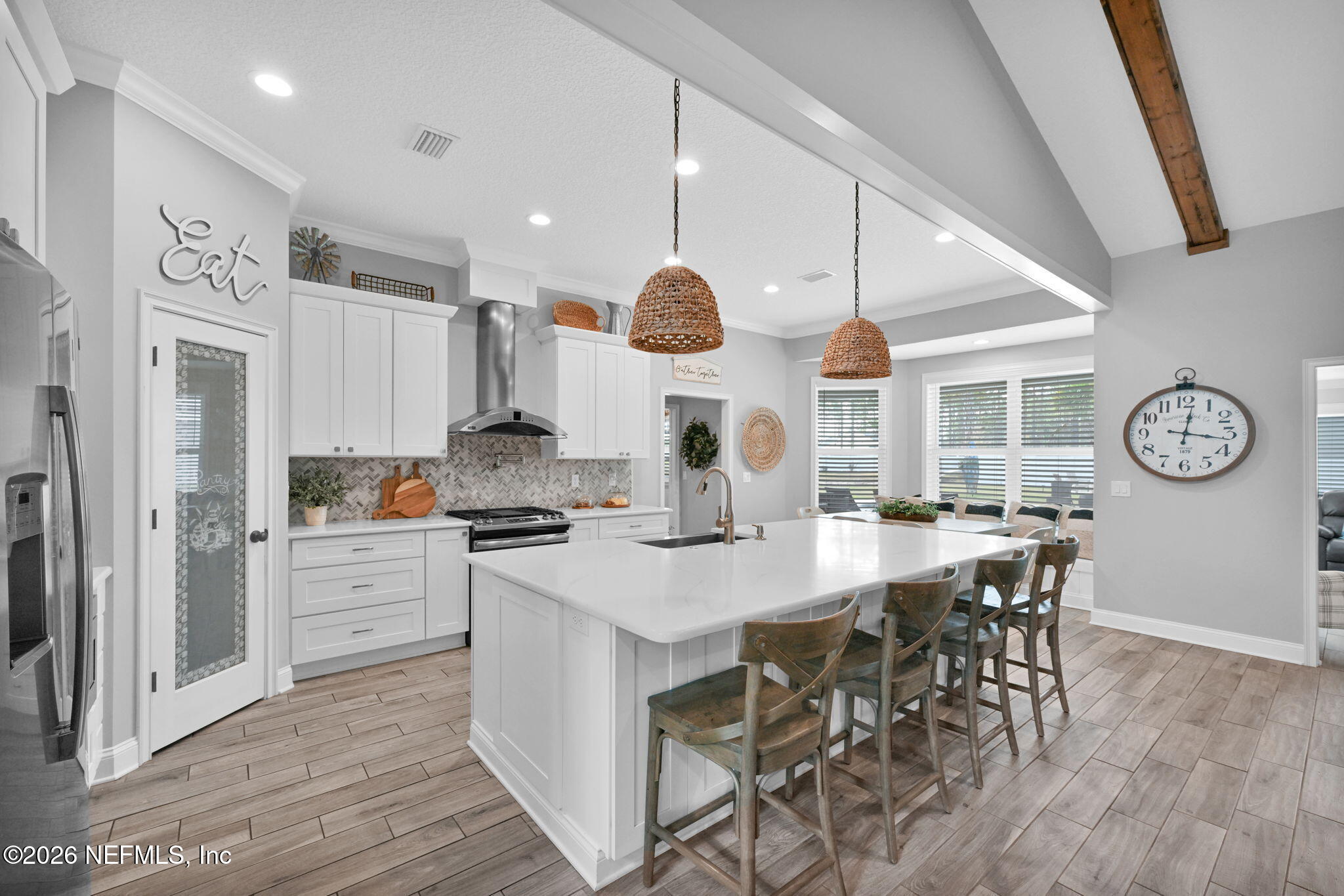 34446 Mitigation Trail Callahan, FL 32011 - Photo 16 of 84 a kitchen with stainless steel appliances a table chairs wooden floors and white cabinets