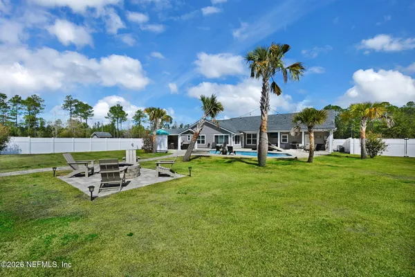 a view of a backyard with swimming pool and furniture