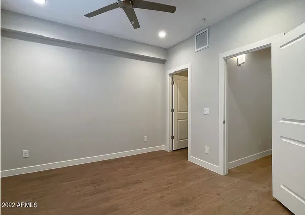 an empty room with wooden floor and closet area