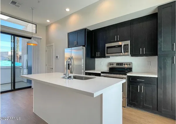 a kitchen with kitchen island a sink stainless steel appliances and cabinets