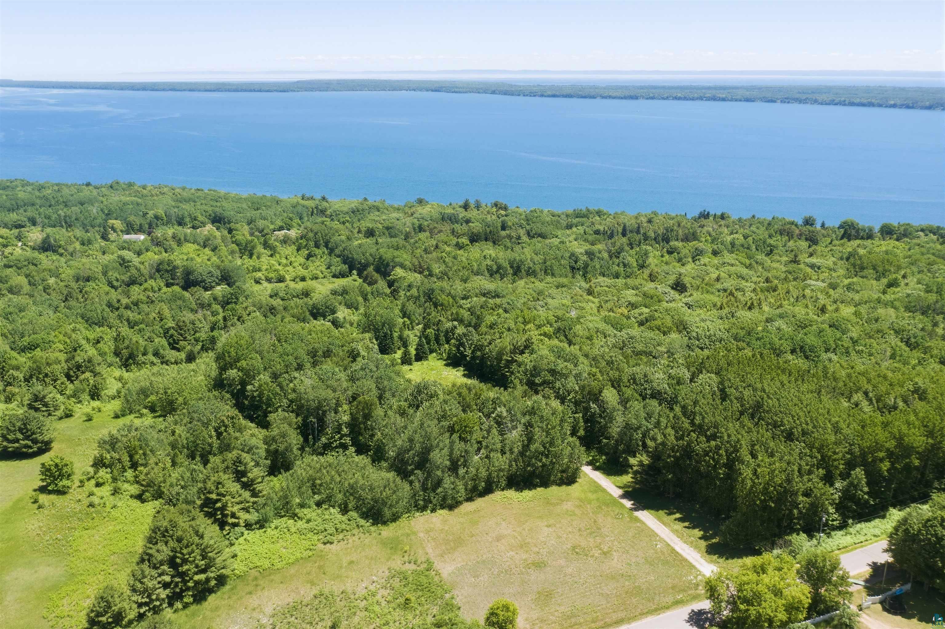 86270 Meyers-Olson Road Bayfield, WI 54814 - Photo 7 of 33 Expansive wooded acreage with a paved road frontage, partially cleared land, and a significant water body visible in the distance