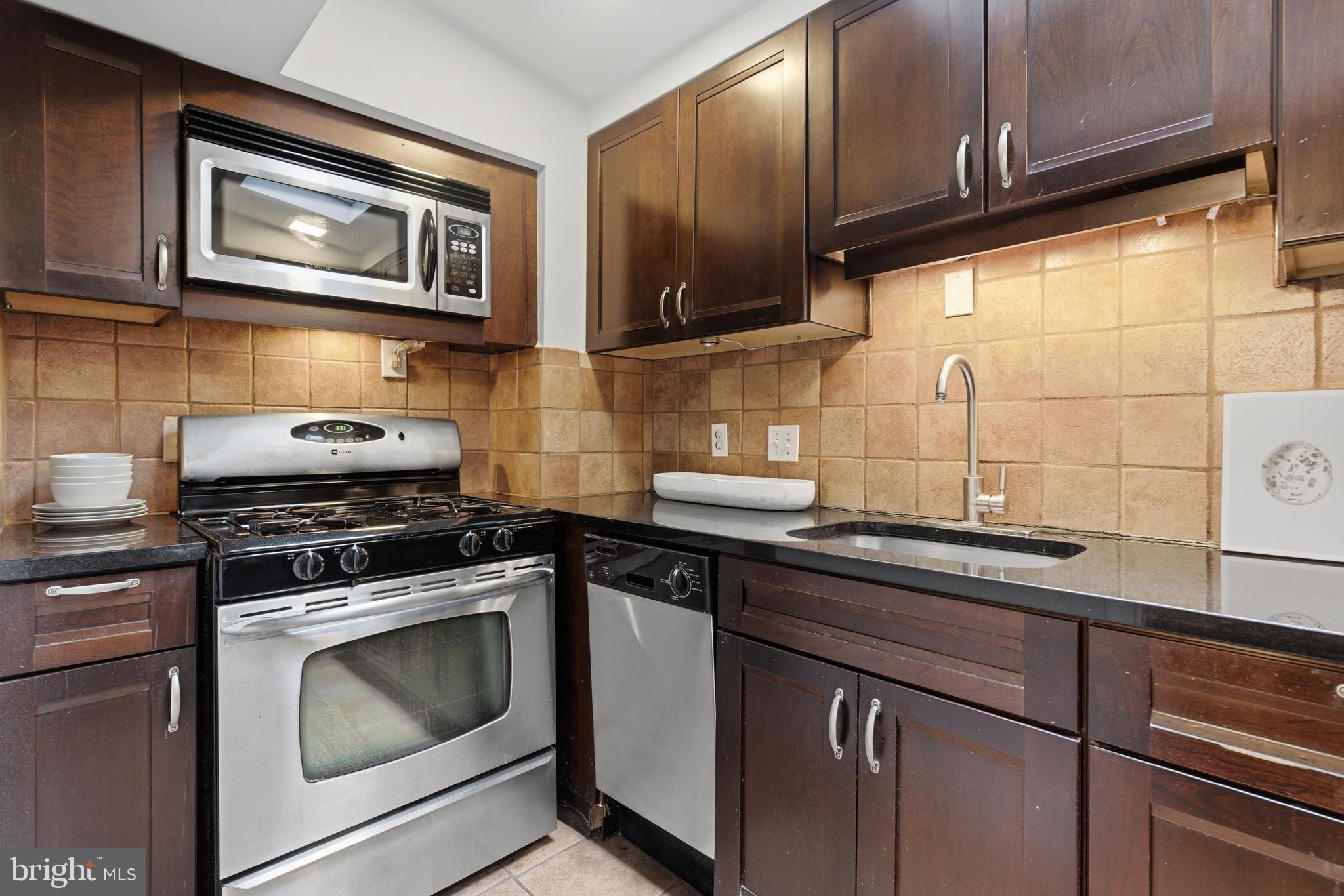 2719 Dumbarton Street Northwest Washington, DC 20007 - Photo 11 of 32 a kitchen with stainless steel appliances granite countertop a stove and a microwave
