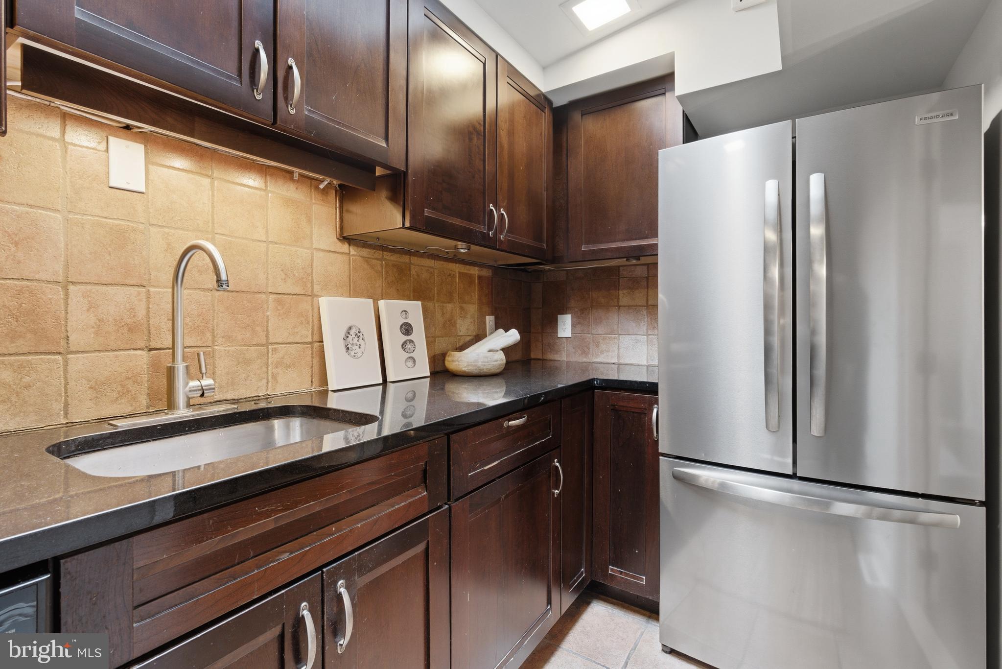 2719 Dumbarton Street Northwest Washington, DC 20007 - Photo 12 of 32 a kitchen with stainless steel appliances a refrigerator and cabinets