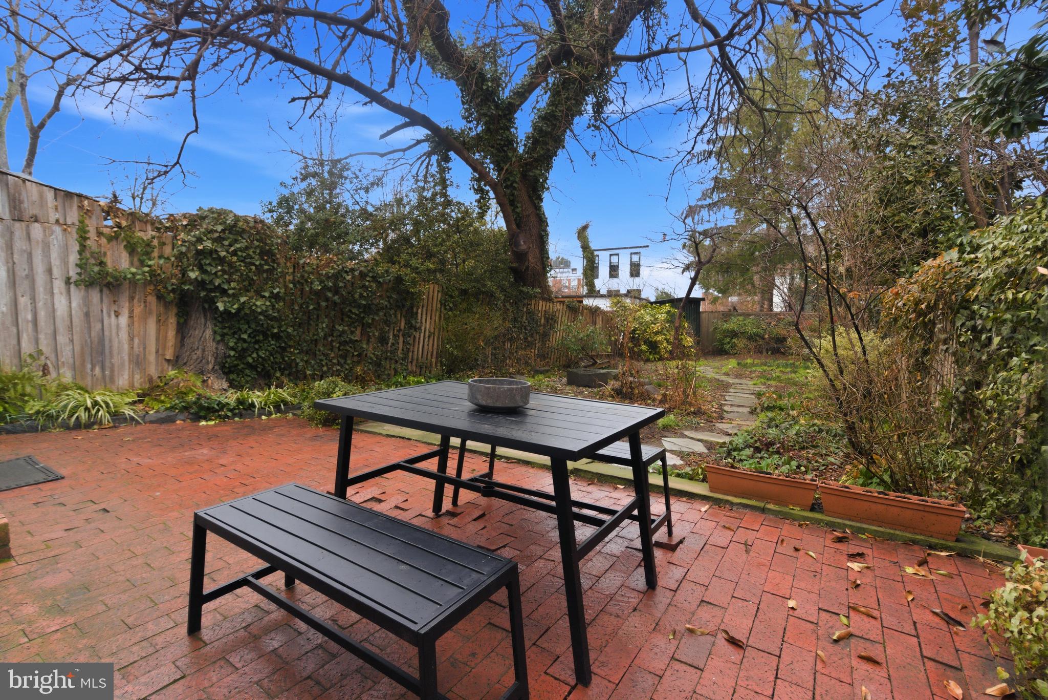 2719 Dumbarton Street Northwest Washington, DC 20007 - Photo 25 of 32 a wooden bench sitting in the middle of a backyard