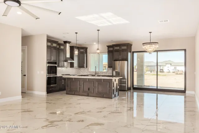 a large kitchen with kitchen island a large counter space a sink appliances and cabinets