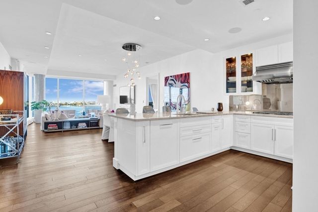 a kitchen with stainless steel appliances sink cabinets and wooden floor
