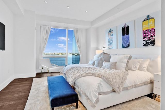 a living room with a bed and a wooden floor