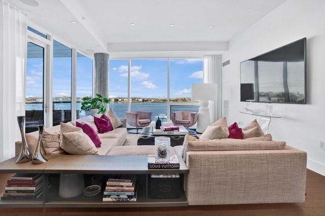 a living room with furniture kitchen view and a window