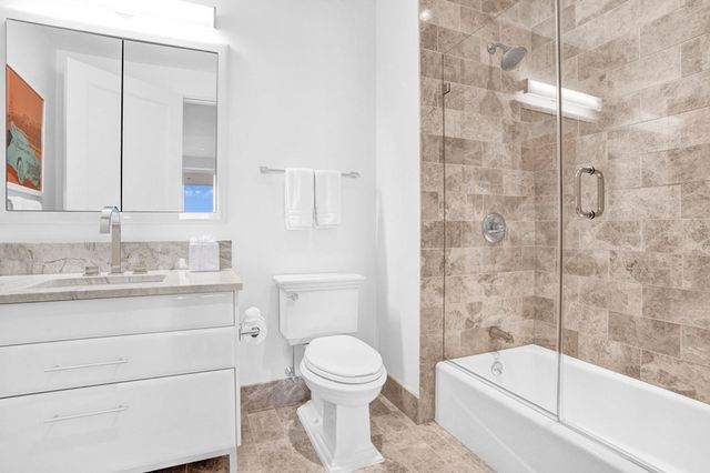 a bathroom with a granite countertop toilet a sink and a bathtub