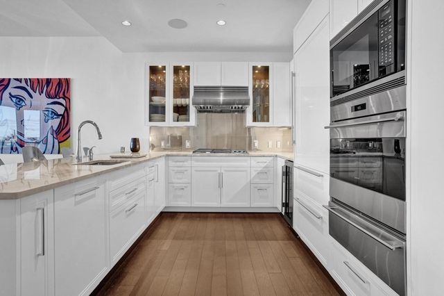 a kitchen with white cabinets and appliances
