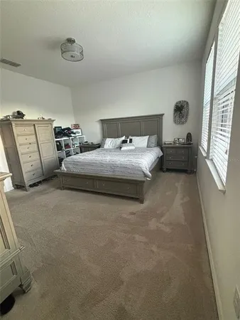 a bed sitting in a bedroom next to a window