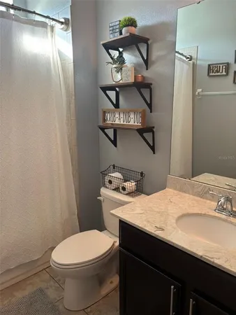 a bathroom with a sink vanity and toilet