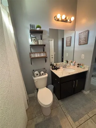 a bathroom with a granite countertop bathtub shower sink vanity and toilet