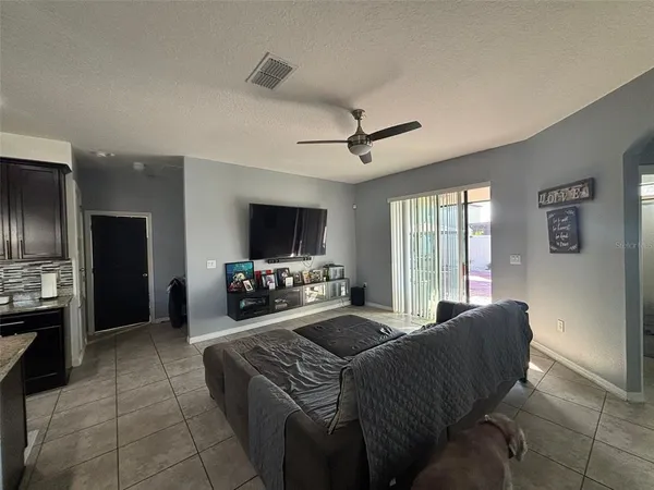 a living room with furniture a flat screen tv and a window