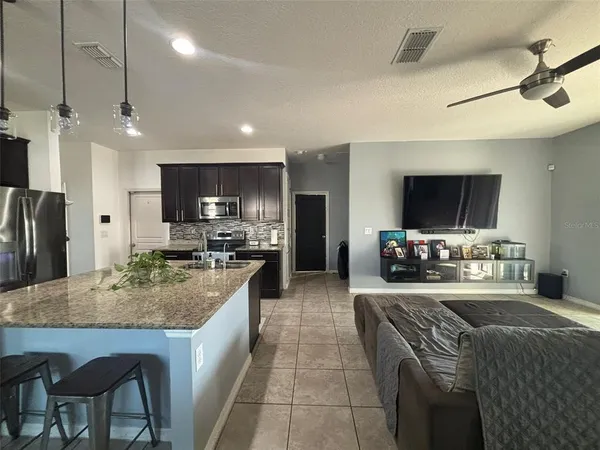 a kitchen with kitchen island granite countertop a sink counter top space appliances and cabinets