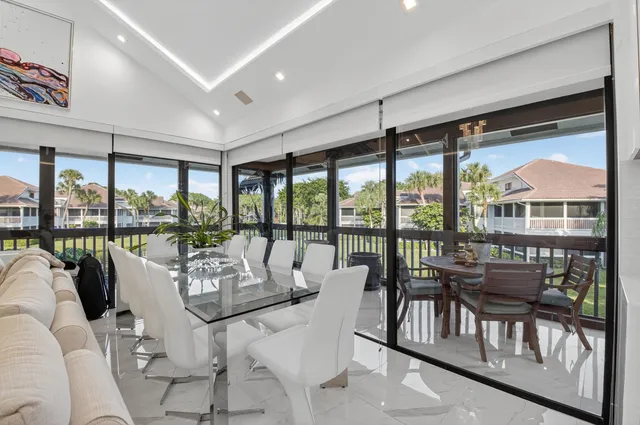 a living room with furniture and floor to ceiling windows