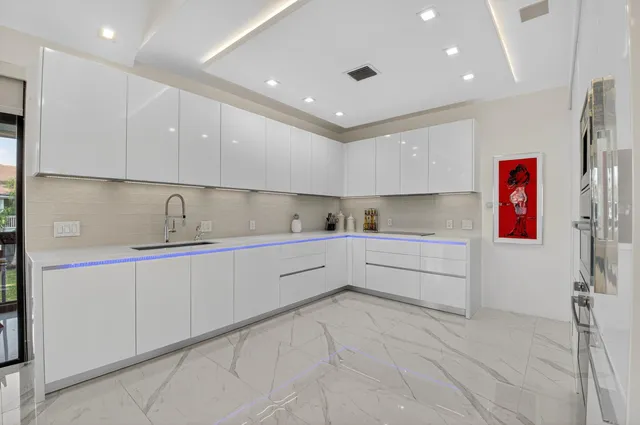 a kitchen with white cabinets and sink