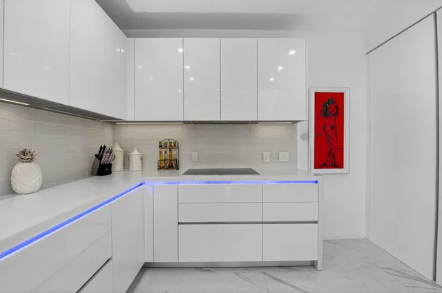 a living room with furniture kitchen view and a chandelier