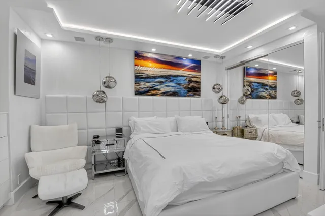 a bedroom with a bed a couch and a flat screen tv