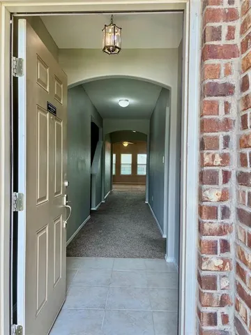 a view of a hallway with a door and wooden floor