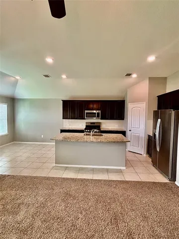 a view of kitchen with furniture and refrigerator