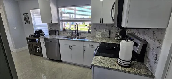 a kitchen with sink a microwave a stove and refrigerator