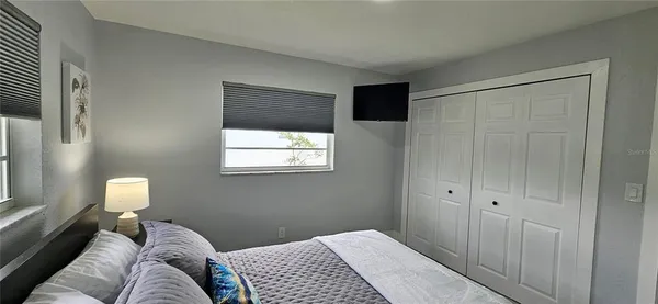 a bedroom with a bed and a lamp on dresser