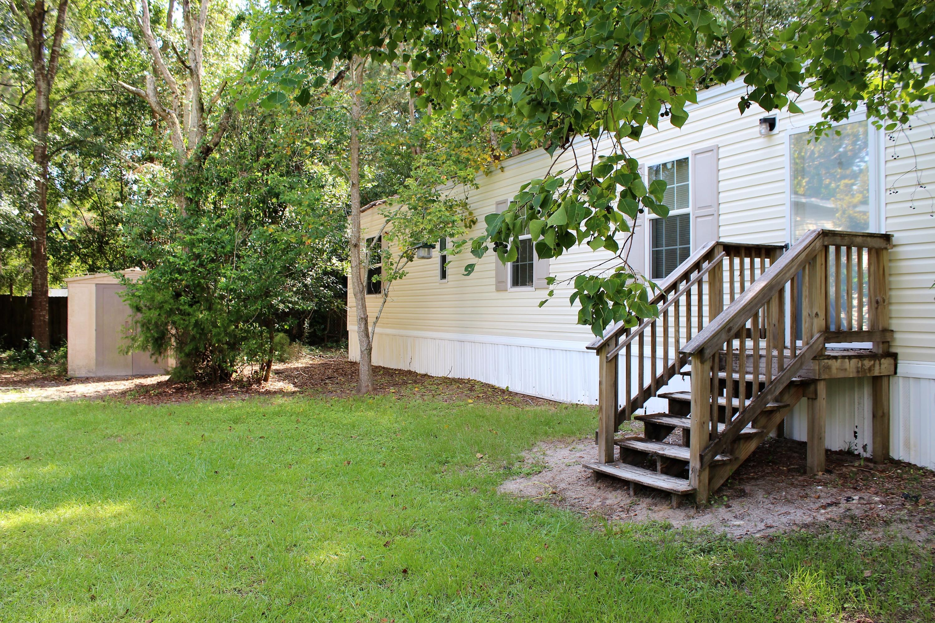 a view of a house with backyard and a tree