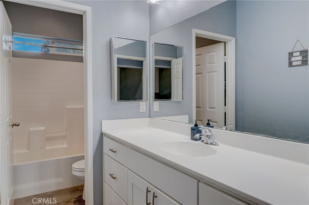 1667 Constant Trail San Jacinto, CA 92582 - Photo 18 of 44 a bathroom with a sink a toilet and a large mirror