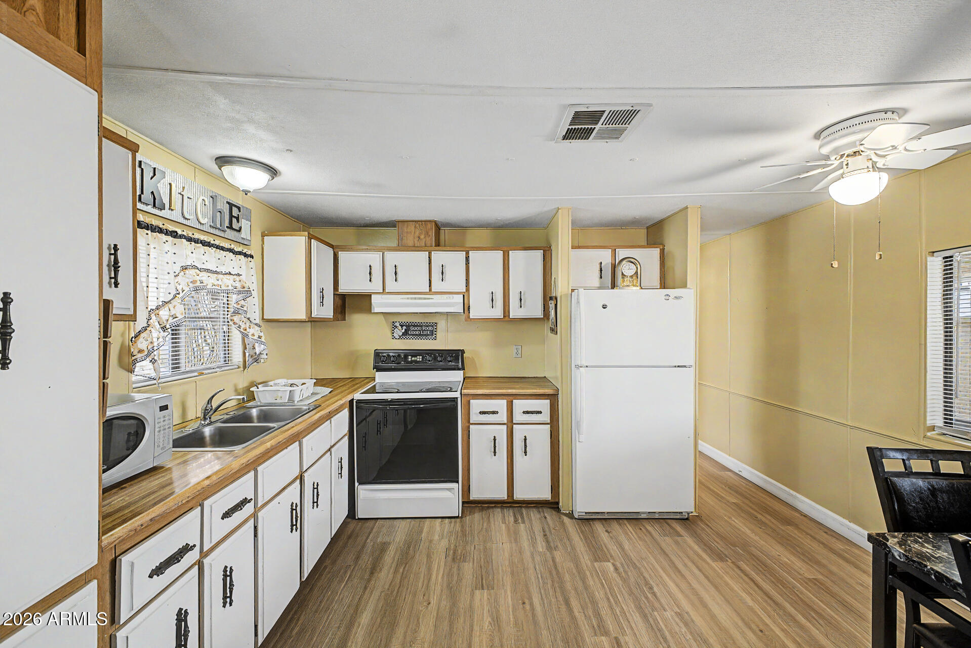 535 South Alma School Road, Unit 40 Mesa, AZ 85210 - Photo 13 of 33 a kitchen with stainless steel appliances granite countertop a refrigerator a sink dishwasher a stove and white countertops with wooden floor
