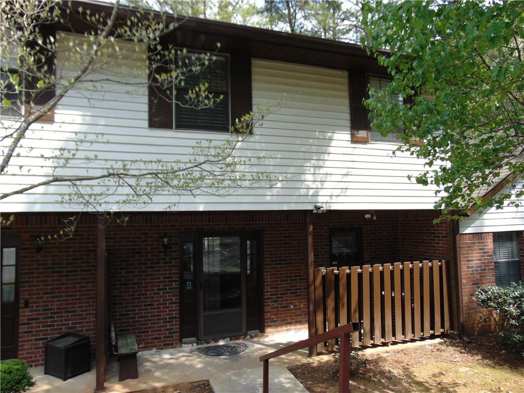 a view of a house with a door and a large tree