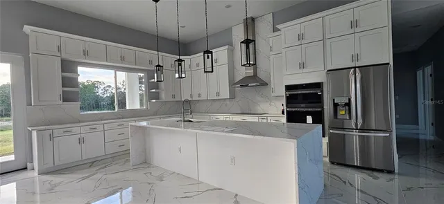 a kitchen with kitchen island white cabinets and refrigerator
