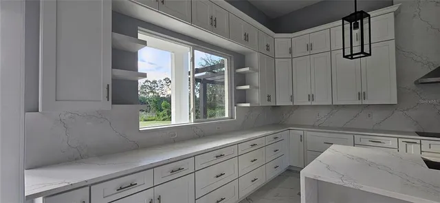 a kitchen with a white cabinets and window