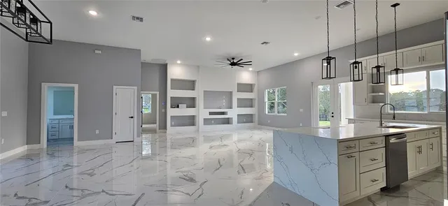 a large kitchen with stainless steel appliances kitchen island granite countertop a large counter top and sink