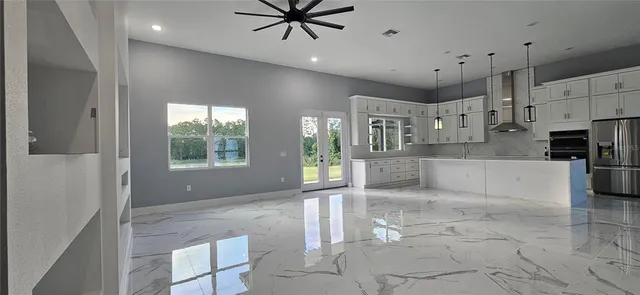 a large kitchen with stainless steel appliances kitchen island granite countertop a refrigerator and a stove top oven