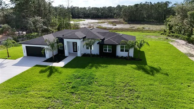 a view of a house with pool and a yard