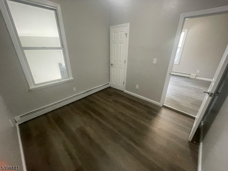 160 12th Avenue, Unit 2 Paterson, NJ 07501 - Photo 13 of 17 an empty room with wooden floor and windows