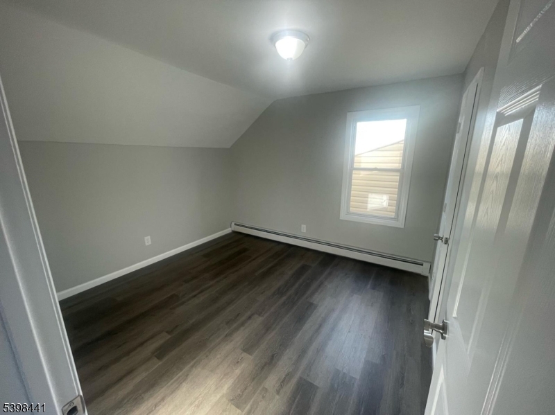 160 12th Avenue, Unit 2 Paterson, NJ 07501 - Photo 6 of 17 an empty room with wooden floor and windows