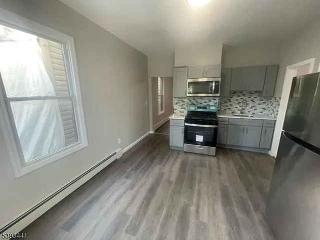 a kitchen with kitchen island wooden floors and stainless steel appliances