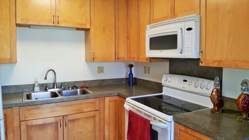 5004 Awawa Road Eleele, HI 96705 - Photo 17 of 21 a kitchen with stainless steel appliances granite countertop a sink stove and white cabinets