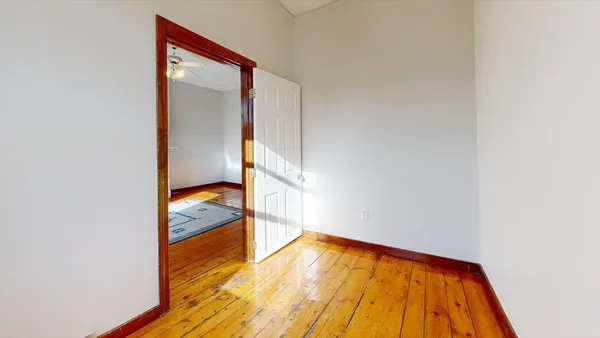 a view of an empty room with wooden floor