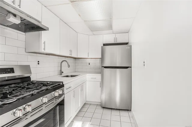 a kitchen with stainless steel appliances a refrigerator sink and cabinets
